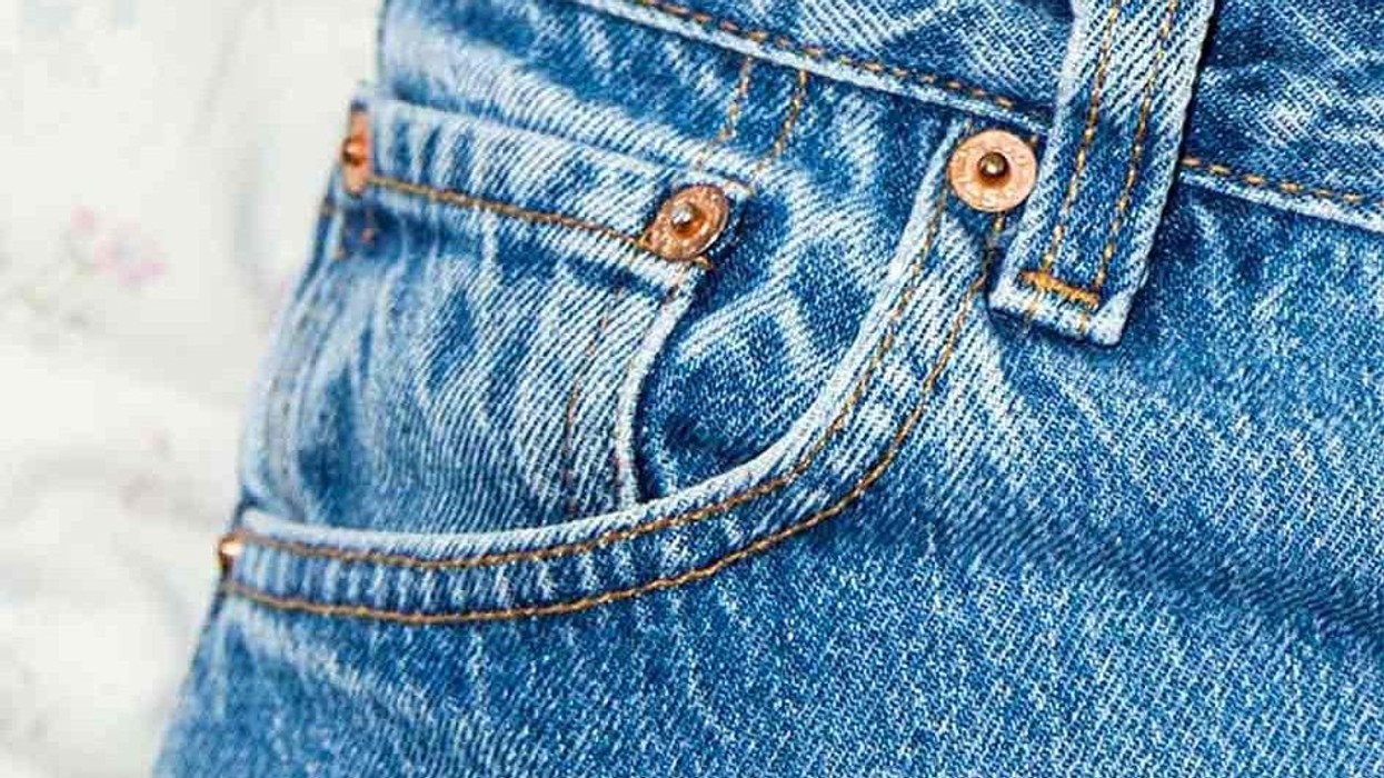 Gros plan sur la petite poche d'un jean avec une montre de poche ancienne à côté