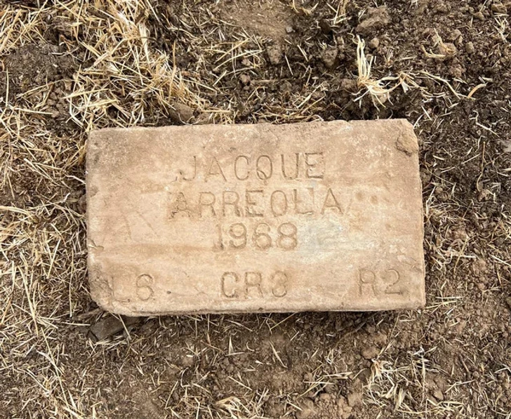 Pierre ancienne avec des inscriptions, posée sur le sol