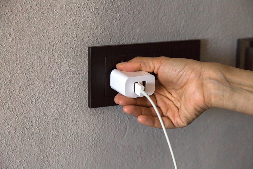 Enfant curieux près d'une prise avec un chargeur