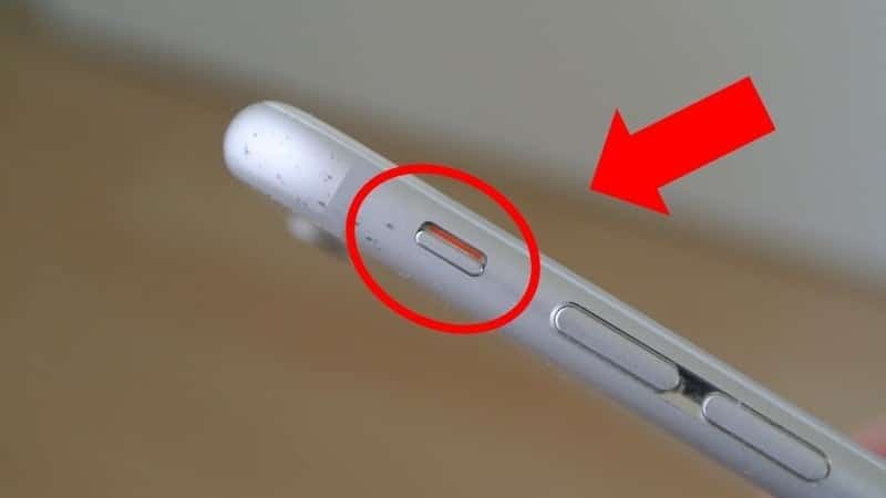 Main tenant un téléphone, le doigt sur le bouton de volume pour lancer une vidéo