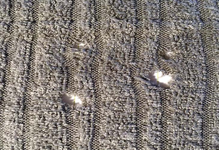 Boucle de ceinture et bord de sac à main près d'un tissu