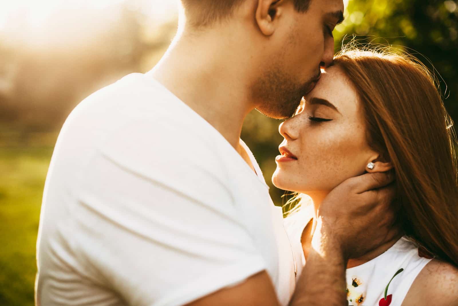 Un baiser doux est déposé sur le front d'une personne, geste d'affection pure.