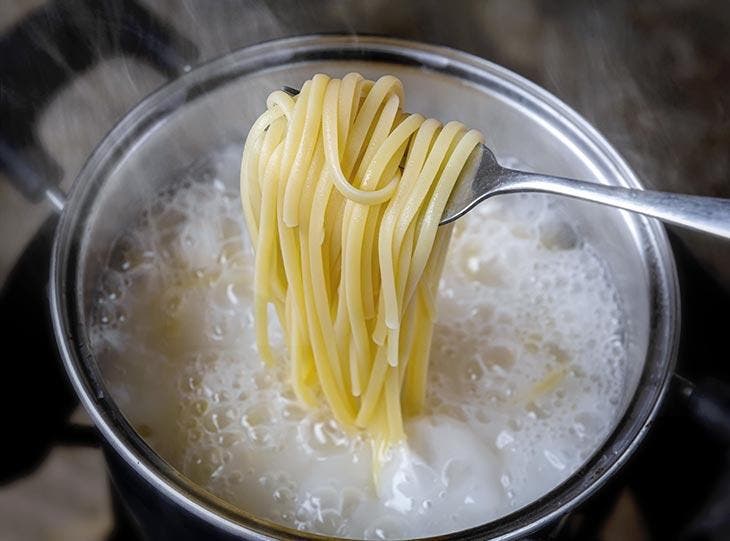 Cuisson des spaghettis dans une marmite d'eau bouillante