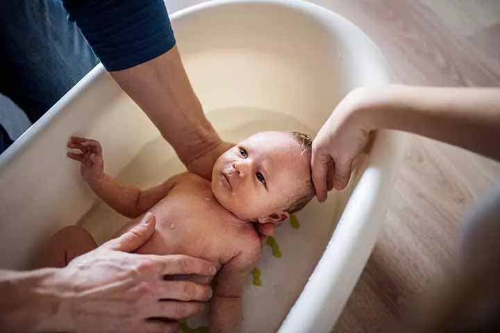 Des parents qui donnent le bain à leur bébé