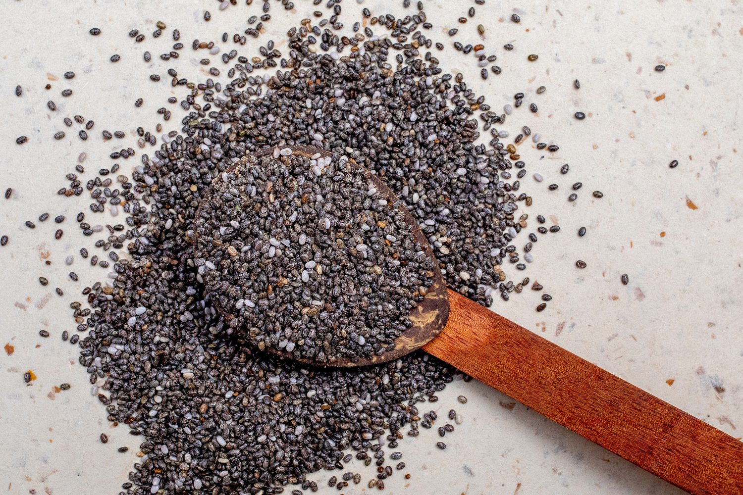 Graines de chia brunes et blanches, mises en valeur, illustrant leur potentiel nutritionnel.