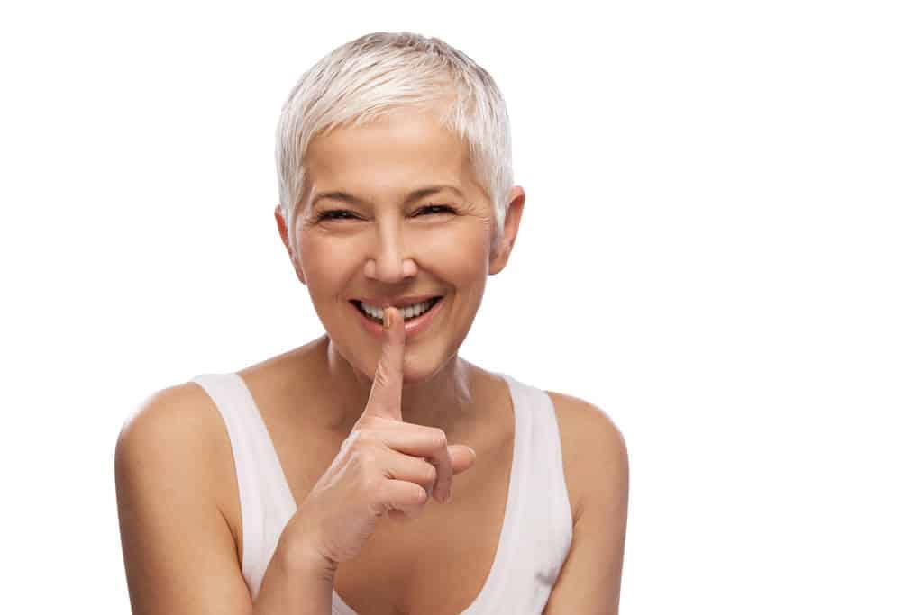Femme buvant de l'eau et souriante, habitudes saines