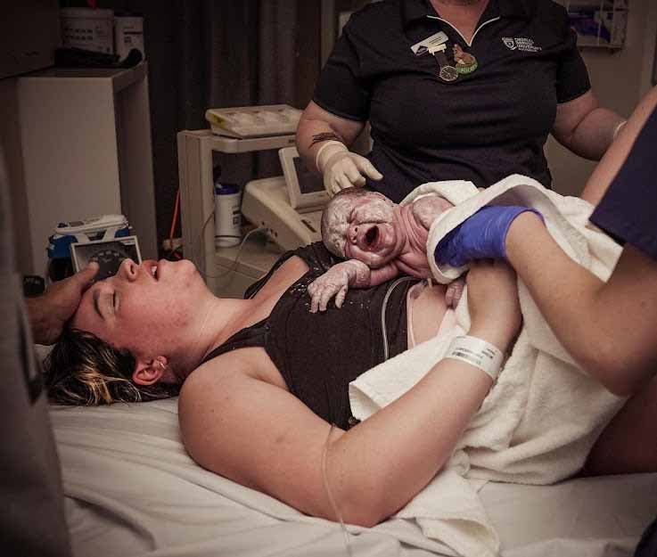 Le papa caressant le front de sa femme qui vient tout juste d’accoucher