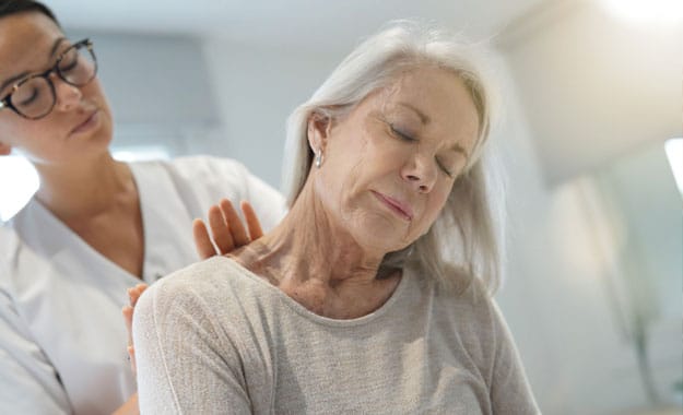Personne âgée bénéficiant d'un moment de détente et de soin par un massage des mains