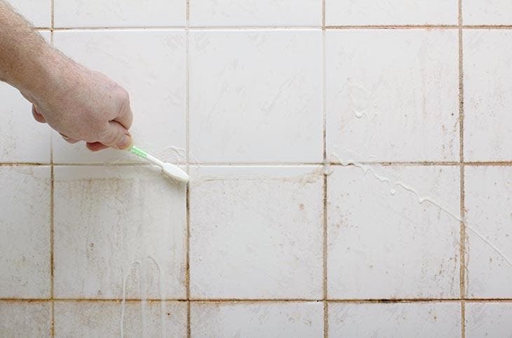 Nettoyage des joints et des carreaux de salle de bain avec une brosse à dents 