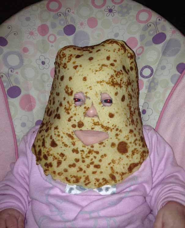 Un papa qui dépose une crêpe sur le visage de son bébé