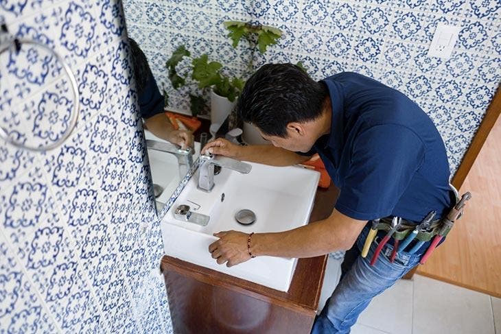 Un plombier répare le lavabo