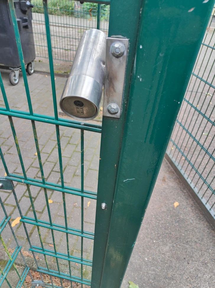 Tube métallique fixé près de poubelles