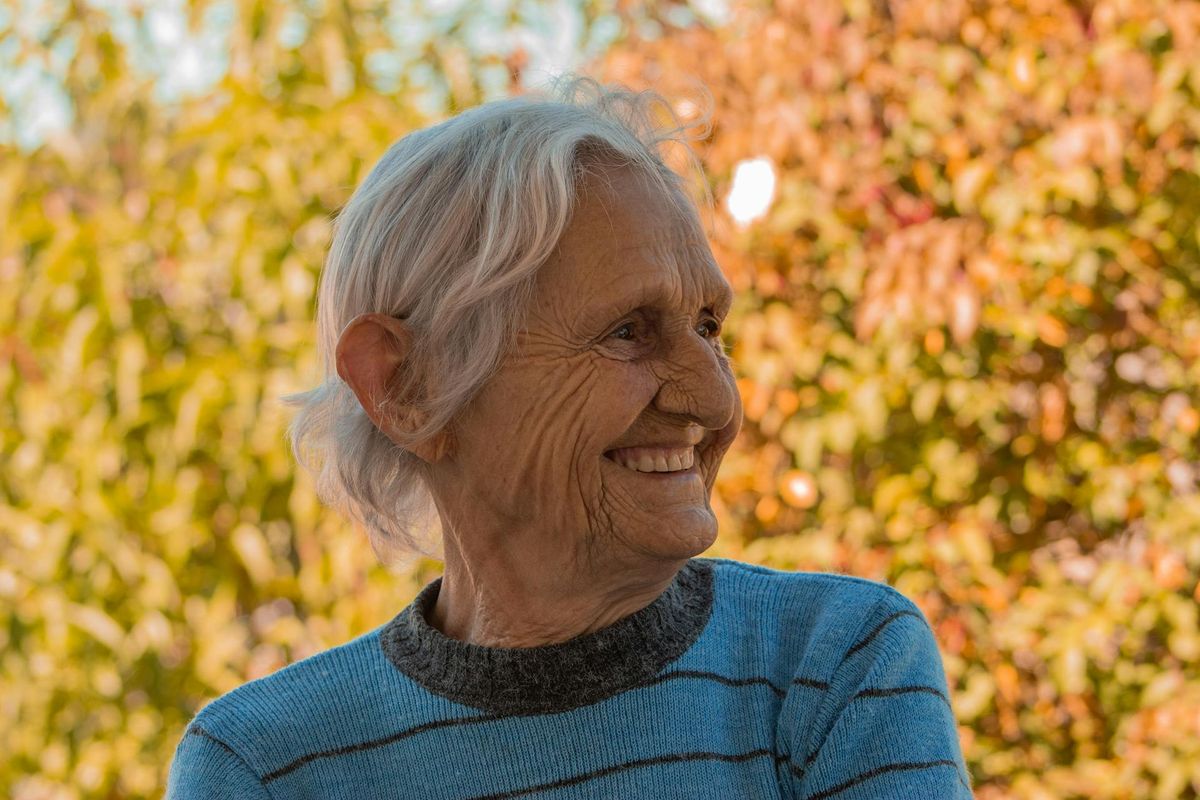 Une grand-mère tenant un bébé, regardant par la fenêtre d'un café sous la pluie