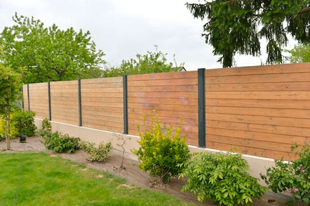 Clôture opaque en bois moderne délimitant un jardin