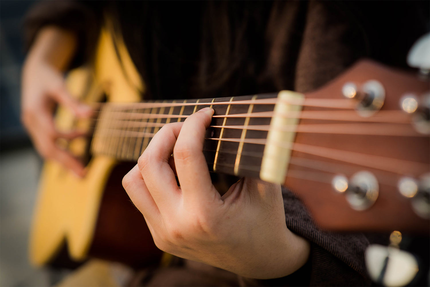 Guitare acoustique posée sur un lit
