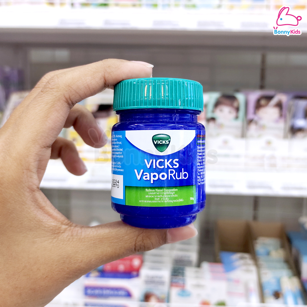 Personne appliquant du VapoRub sur ses tempes