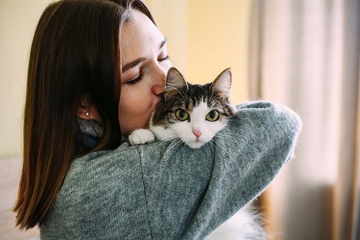 Femme câlinant un chat – source : spm