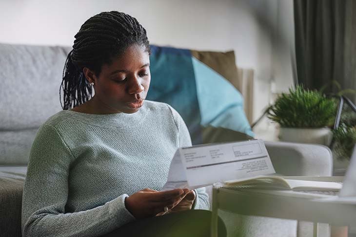 Femme qui examine sa facture d’électricité – source : spm