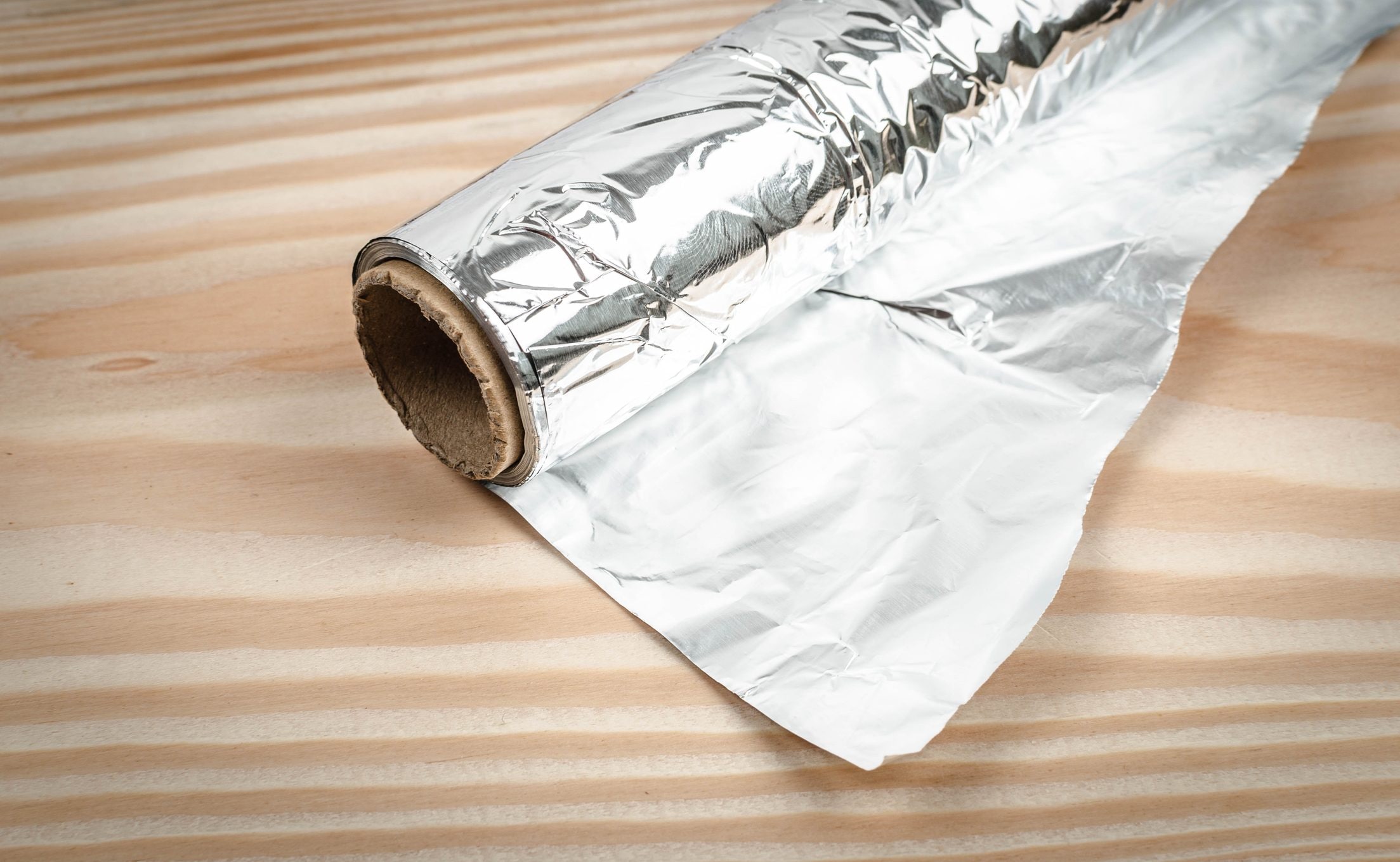Feuille de papier aluminium brillante et mate tenue entre deux mains
