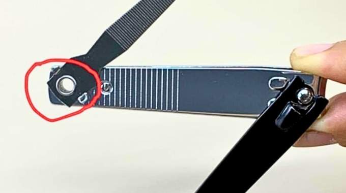 Gros plan sur le trou d'un coupe-ongles, illustrant son design fonctionnel