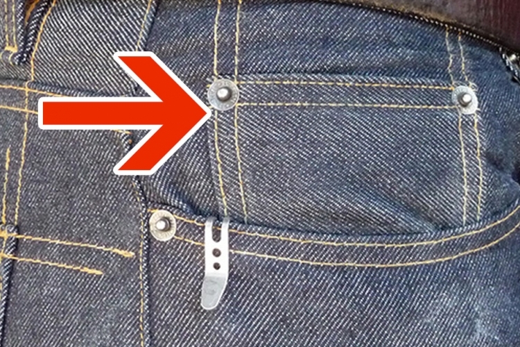 Détail de la petite poche sur un jean bleu
