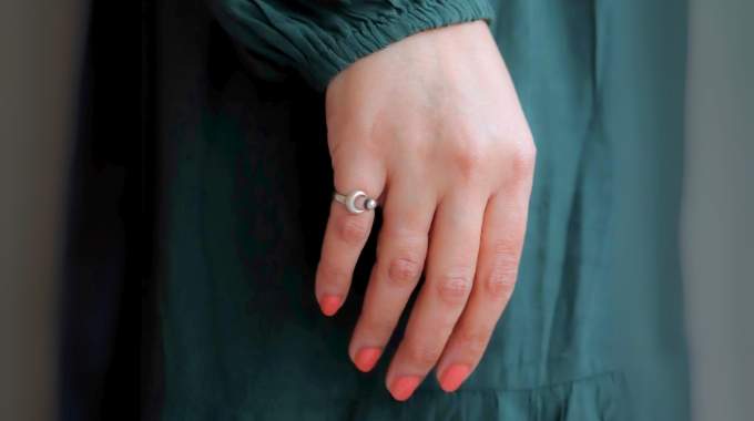 Gros plan sur la main d'une femme portant une bague fine à l'auriculaire droit