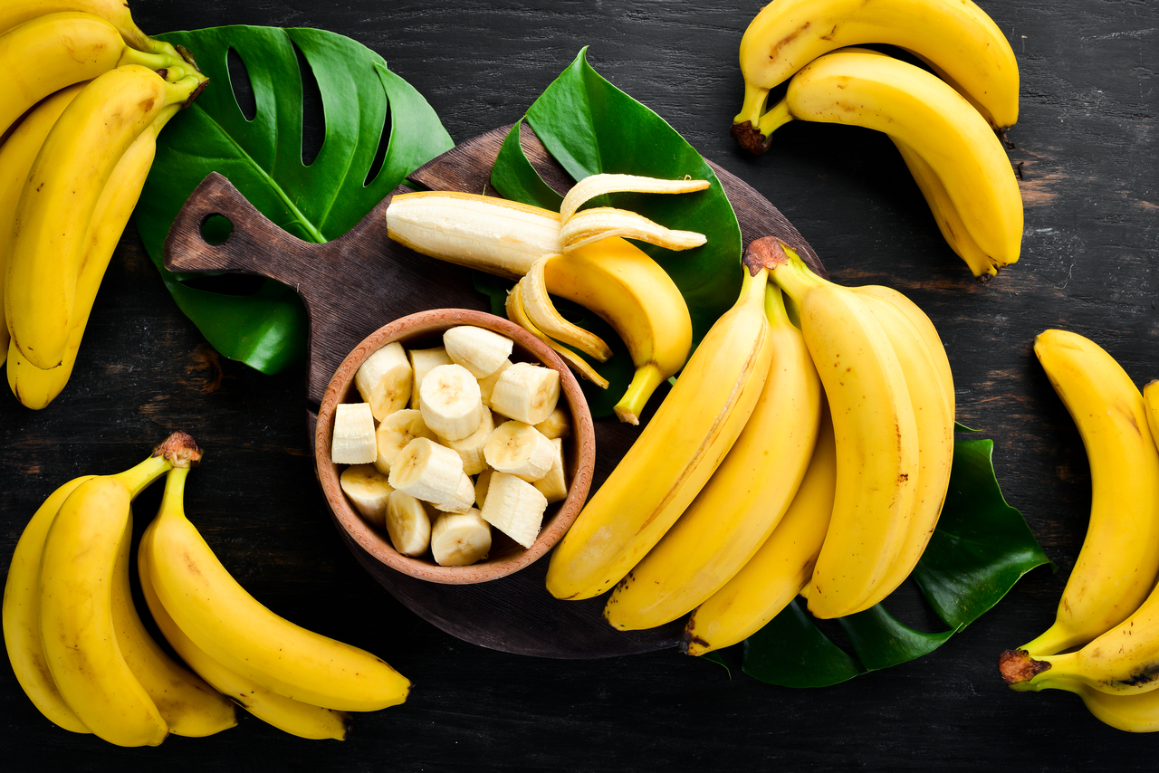 Femme d'âge mûr, heureuse, tenant une banane et souriant à la caméra