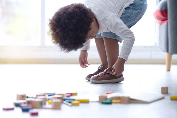 Un enfant qui met ses chaussures – source : spm