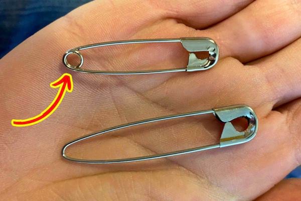 Personne tenant une épingle de sûreté ouverte, montrant la boucle
