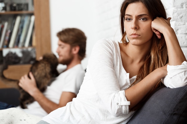 Femme regardant par la fenêtre, semblant réfléchir ou mélancolique