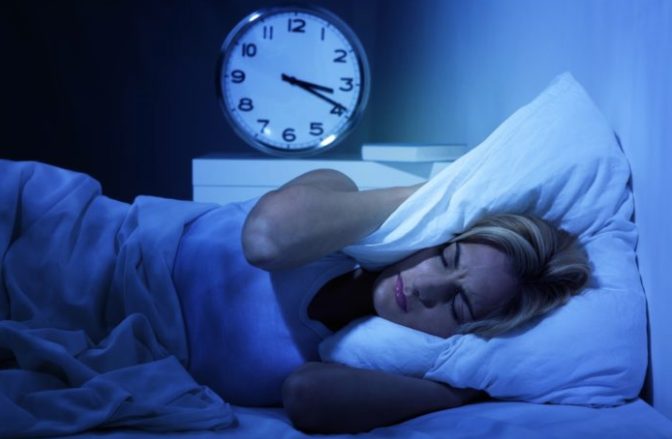 Réveil digital affichant 3h00 sur une table de nuit